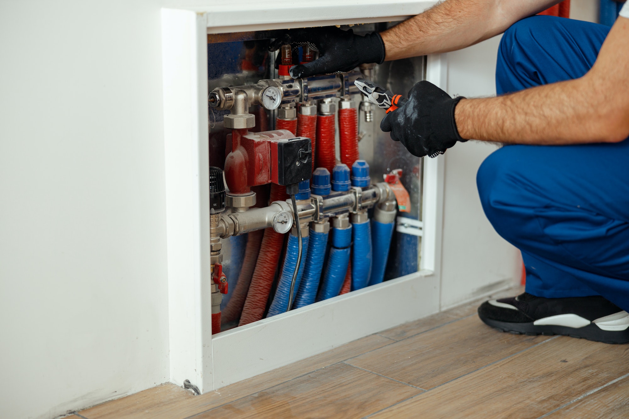 Cropped shot of technician, plumber in protective gloves checking water pipes and meter counter